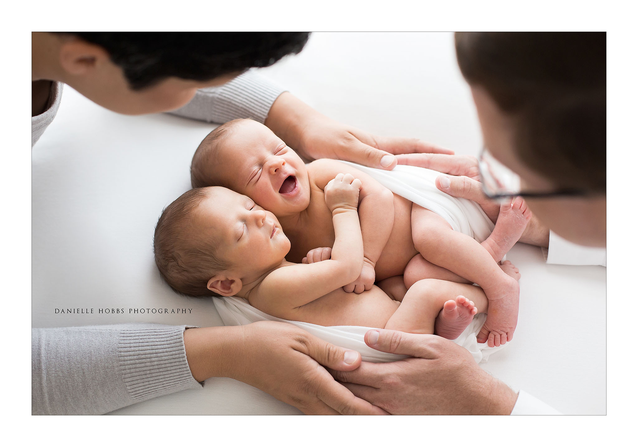 Identical twin boys with parents hands